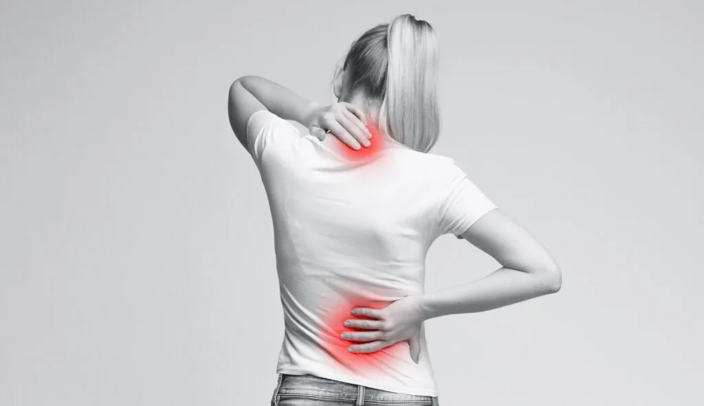 Woman holding neck and lower back with red pain indicators showing injury areas